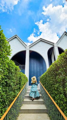 a woman is walking down stairs in front of a building at Hotel Labaris Khao Yai in Mu Si
