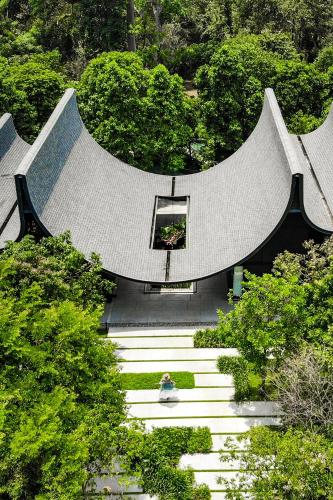 a building with a bunch of stairs and trees at Hotel Labaris Khao Yai in Mu Si