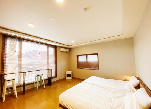 a bedroom with a bed and a large window at House COCOA in Hakodate
