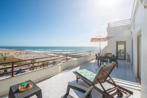 a balcony with a view of the beach at Costa Beach Apartment by The Portuguese Butler in Costa da Caparica