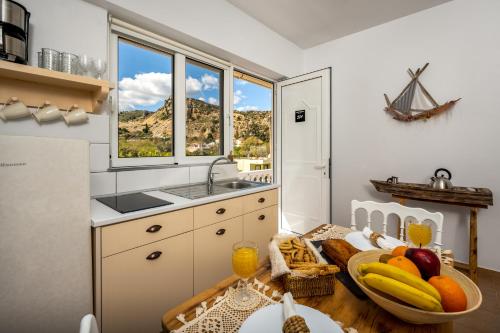 a kitchen with a table with fruit on it at Afroditi Superior Apartments in Archangelos