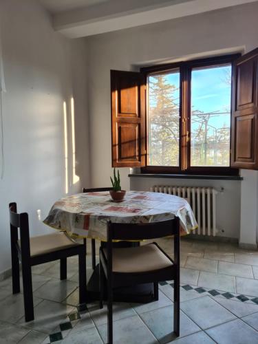 cocina con mesa, sillas y ventana en Appartamento con giardino, en Pomarance