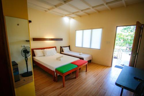 a bedroom with a bed and a table and a window at Ana-as Apartelle (GGL) in Panglao Island
