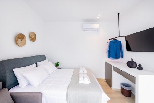 a small room with a bed and a tv at Sunwaves Beach studio I in Ialyssos