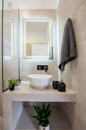 a bathroom with a white sink and a mirror at Sunwaves Beach studio I in Ialyssos