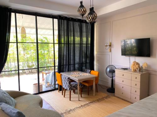 ein Wohnzimmer mit einem Tisch und Stühlen sowie einem großen Fenster in der Unterkunft Spacious fancy house/centrally located in Hinkong