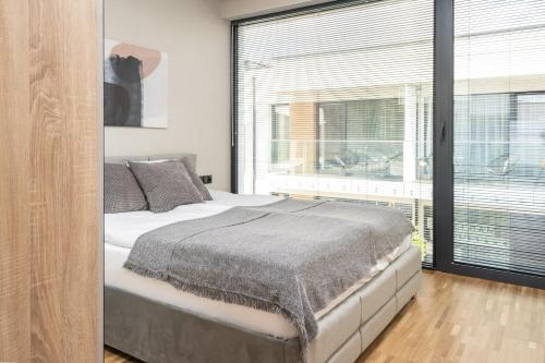 a bedroom with a bed and a large window at Apartamenty Olimpijska by RENT4YOU in Olsztyn