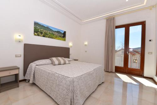 a bedroom with a bed and a large window at Relais Milò in Agerola