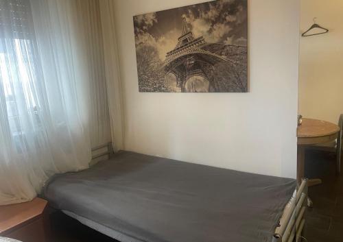 uma cama num quarto com uma fotografia na parede em MAM Monteurzimmer em Seligenstadt