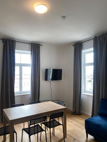 a dining room table with chairs and a blue couch at Krems am Campus in Krems an der Donau