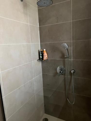 a shower with a shower head in a bathroom at Cozy new townhouse for 6 people! in Salalah