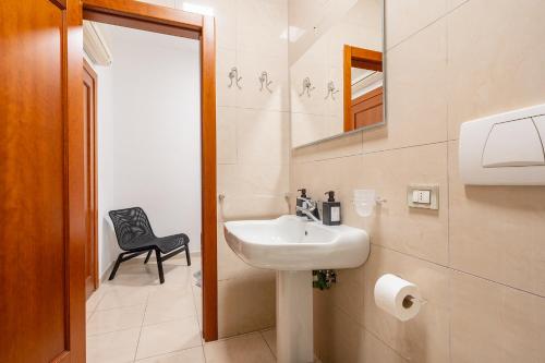 a bathroom with a sink and a black chair at Home Abate Gimma 170 in Bari