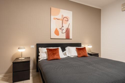 een slaapkamer met een bed met 2 lampen en een schilderij bij Home Abate Gimma 170 in Bari