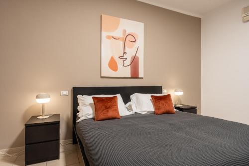 a bedroom with a bed with two lamps and a painting at Home Abate Gimma 170 in Bari