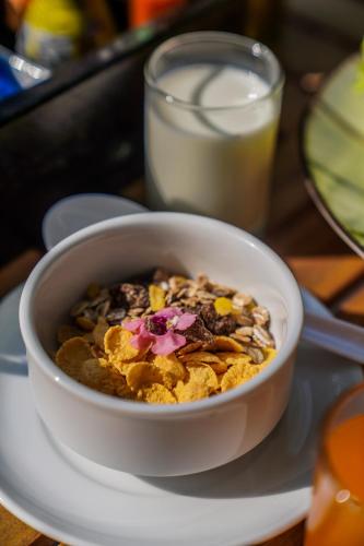 a bowl of cereal on a plate with a glass of milk at Hotel Labaris Khao Yai in Mu Si
