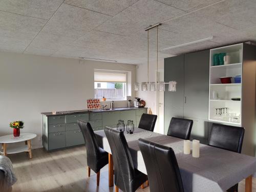 een keuken en eetkamer met een tafel en stoelen bij Villa-Amby in Ringkøbing