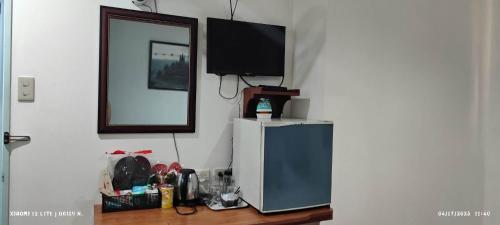 une télévision installée au-dessus d'un réfrigérateur dans l'établissement DUCK INN AND RESTAURANT, à Manille