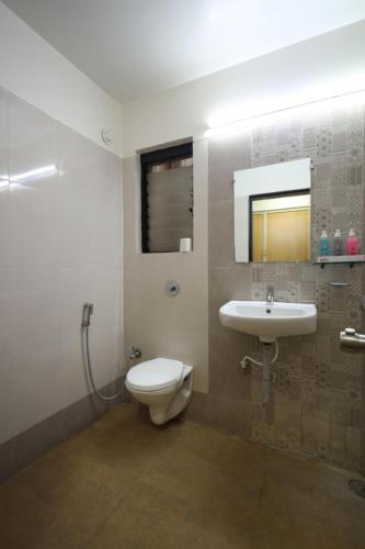 a bathroom with a toilet and a sink at Saish Hotel Shirdi in Shirdi