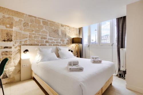 une chambre avec un grand lit avec deux serviettes dessus dans l'établissement Pick A Flat's Apartment on l'Ile de la Cité - Quai de L'Horloge, à Paris