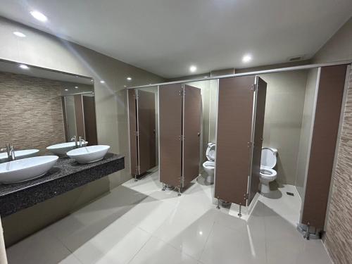La salle de bains est pourvue de 2 lavabos et de 2 toilettes. dans l'établissement Bordin Hotel, à Ubon Ratchathani