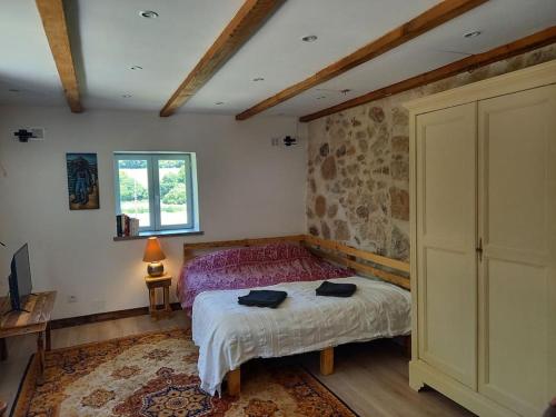 a bedroom with a bed and a table and a window at Le Studio du Crot Noir in Cussy-en-Morvan