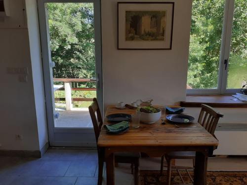 a wooden table with chairs in a room with a window at Le Studio du Crot Noir in Cussy-en-Morvan