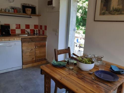 a wooden table in a kitchen with a bowl of grapes at Le Studio du Crot Noir in Cussy-en-Morvan