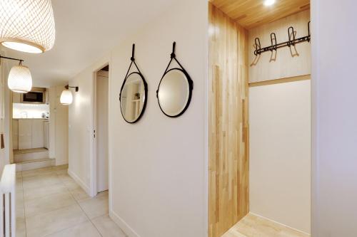 un couloir avec deux miroirs sur le mur dans l'établissement Pick A Flat's Apartment on l'Ile de la Cité - Quai de L'Horloge, à Paris