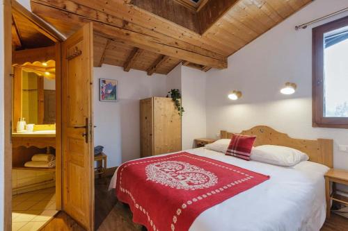 une chambre avec un grand lit avec une couverture rouge dans l'établissement Balcons Anaïte - Duplex 5BR 110m2 - Parking - Central - MtBlancView, aux Houches
