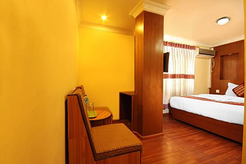 a bedroom with a bed and a table with a chair at Hotel Bubo Himalaya in Kathmandu