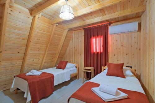 a room with two beds in a log cabin at Atli Bungalow in Fethiye