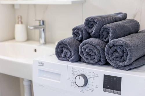 a pile of towels sitting on top of a washing machine at SEASALT Apartments Rafailovichi in Budva