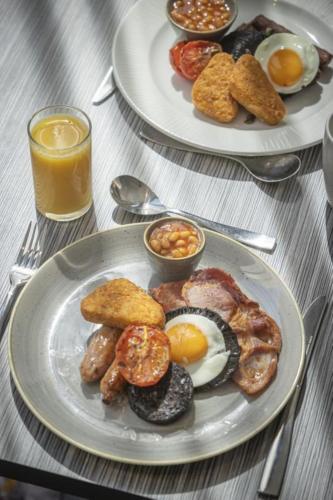 two plates of breakfast food on a table at Maldron Hotel Finsbury Park, London in London