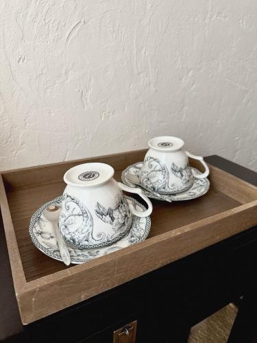 twee theekopjes en schoteltjes op een houten plank bij La demeure des poètes chambres d'hôtes in Cordes-sur-Ciel