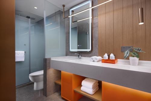 a bathroom with a sink and a toilet at From K Huan Kai Hotel -Changsha Wuyi Plaza IFS Branch in Changsha