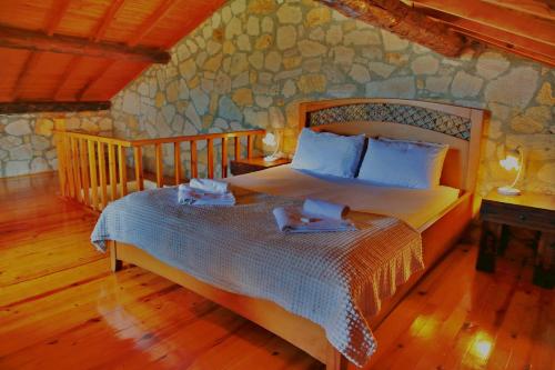 a bedroom with a bed and a stone wall at The Mira House in Ayvalık