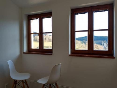 a room with two chairs and two windows at Apartment Felicitas in Kašperské Hory