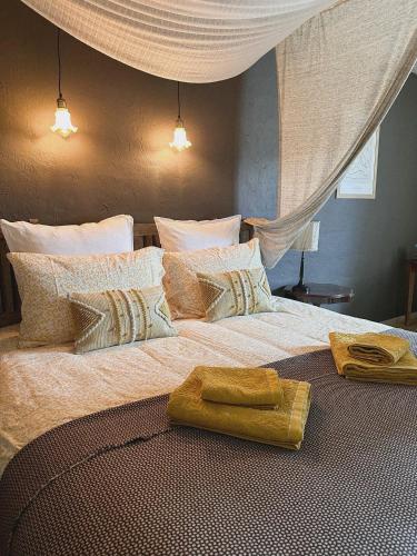 une chambre avec un grand lit avec des oreillers dessus dans l'établissement La demeure des poètes chambres d'hôtes, à Cordes-sur-Ciel