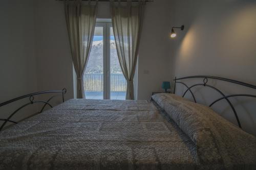 a bedroom with a bed with a large window at Residence Il Poggio in Dorio