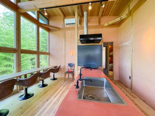 a kitchen with a sink and a tv in a room at 西海岸オーガニック小麦畑1200坪眺望FarmStayYululu in Sumoto