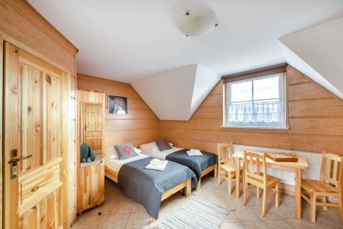 シュツァブニツァにあるGóralskie Domkiのベッドルーム1室(ベッド1台、テーブル、椅子付)
