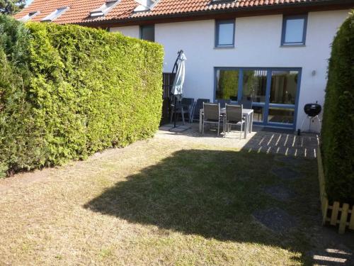 a backyard of a house with a hedge at Haus Zum See, Sommersdorf, Mecklenburgische Seenplatte in Sommersdorf