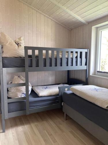 a bedroom with two bunk beds and a window at Bootshus - Strandpark 15 in Grömitz