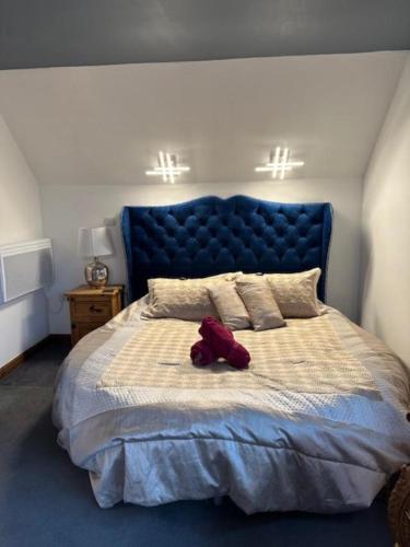 a red teddy bear sitting on top of a bed at Barnfields Retreat in Little Clacton