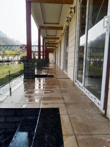 an empty hallway of a building with rain on the ground at Qcent Woods Resort & Spa, Rishikesh in Rishīkesh