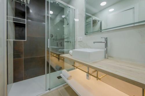 łazienka z umywalką i przeszkloną kabiną prysznicową w obiekcie SUARA Apartamentos 2 w Madrycie