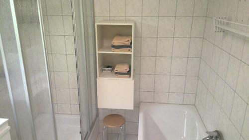 ゲルリッツにあるOtto Apartmentの白いタイル張りのバスルーム(バスタブ、トイレ付)