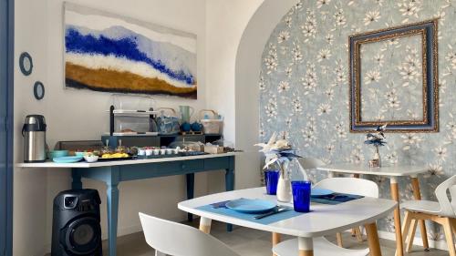 una cucina con tavolo e due tavoli e sedie di TaliaKà B & B a Città di Lipari