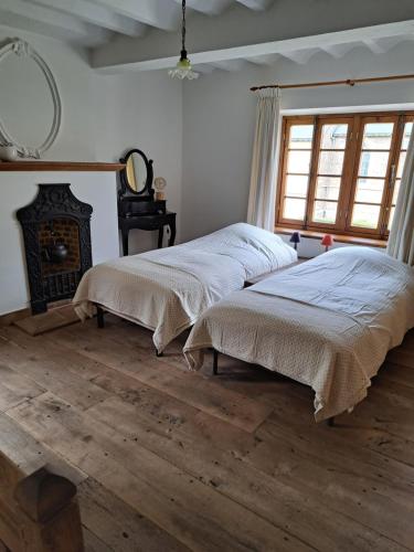 2 łóżka w pokoju z drewnianą podłogą w obiekcie Begijnhof 54 w mieście Sint-Truiden