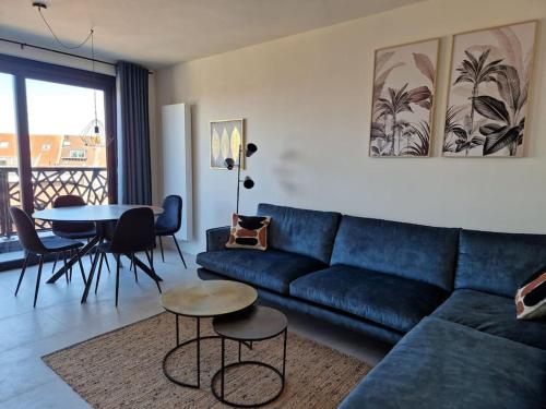 ein Wohnzimmer mit einem blauen Sofa und einem Tisch in der Unterkunft Phoenix in Gent